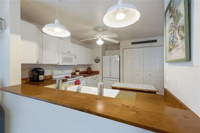 kitchen featuring decorative light fixtures, white appliances, butcher block counters, and white cabinetry