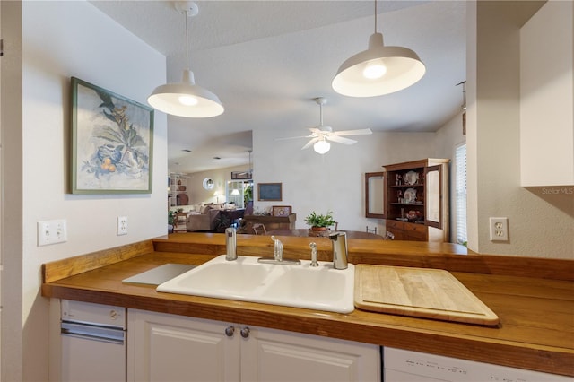 kitchen with decorative light fixtures, a healthy amount of sunlight, sink, and white cabinetry