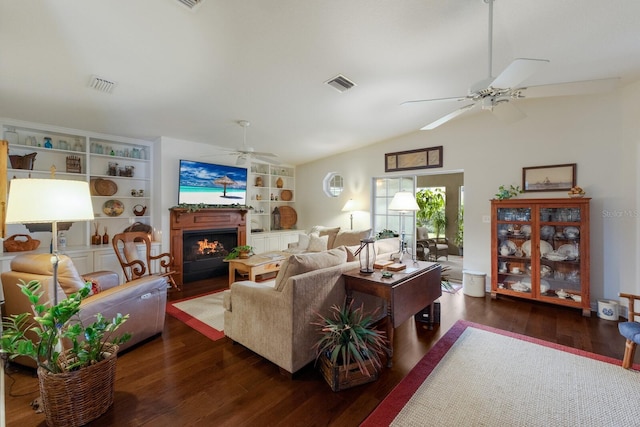 living room featuring ceiling fan, dark wood-type flooring, built in shelves, and vaulted ceiling