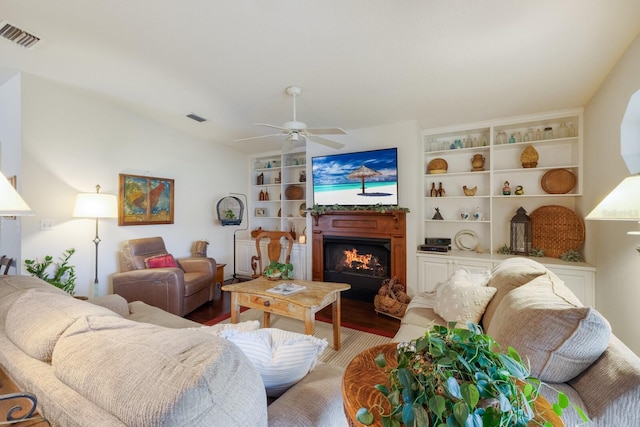 living room with ceiling fan, vaulted ceiling, built in features, and hardwood / wood-style flooring