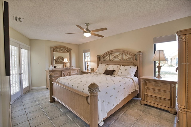 bedroom with tile patterned flooring, ceiling fan, and a textured ceiling