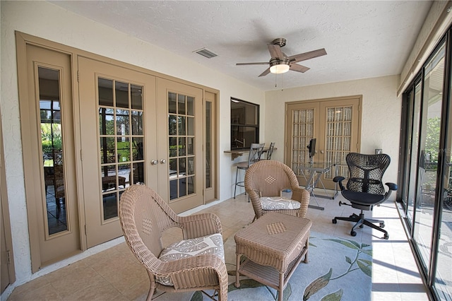 sunroom / solarium with french doors, plenty of natural light, and ceiling fan