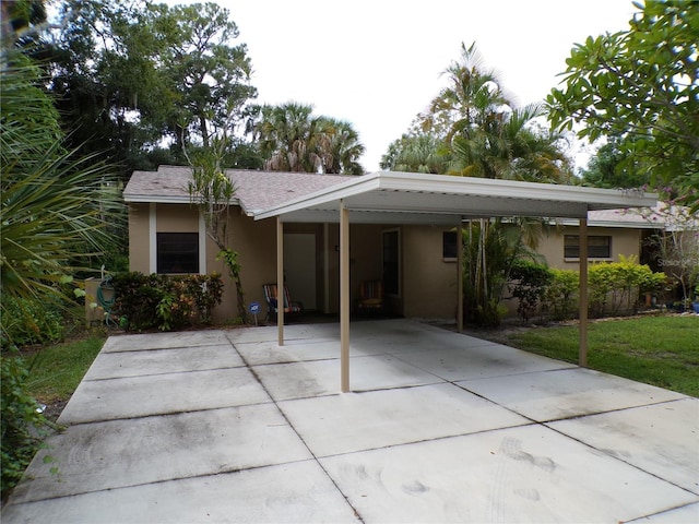 4973 Village Gardens Dr Unit 50, Sarasota, FL 34234 - view of front of house with stucco siding, driveway, a carport, and a front lawn