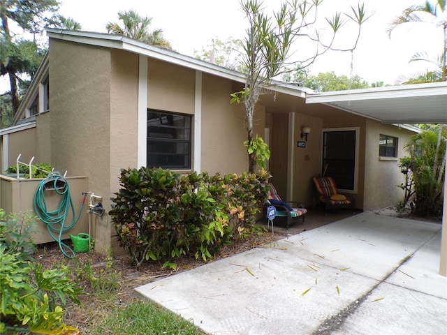 4973 Village Gardens Dr Unit 50, Sarasota, FL 34234 - property entrance with stucco siding and a carport
