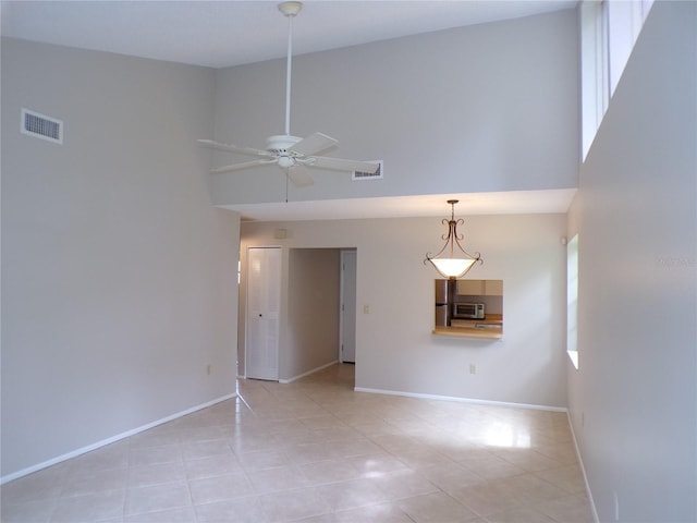 4973 Village Gardens Dr Unit 50, Sarasota, FL 34234 - empty room with a towering ceiling, light tile patterned flooring, and a ceiling fan