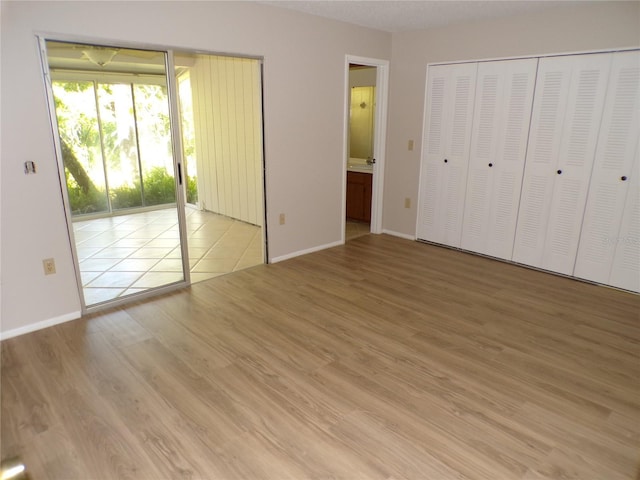 4973 Village Gardens Dr Unit 50, Sarasota, FL 34234 - unfurnished bedroom with access to outside, wood finished floors, and ensuite bath