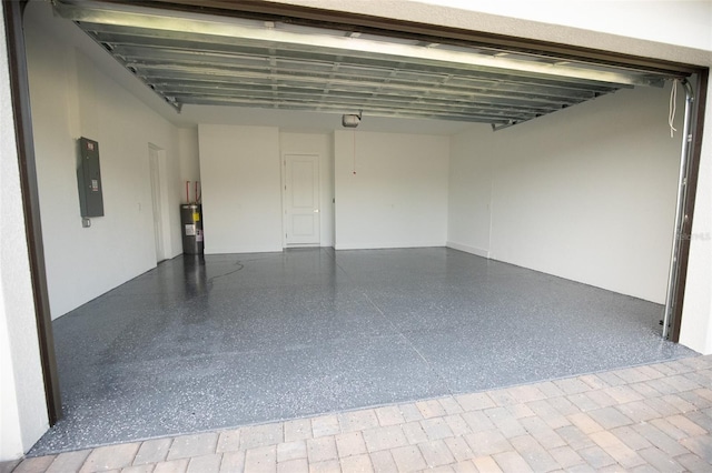 garage featuring electric panel, electric water heater, and a garage door opener