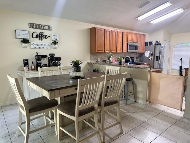 tiled dining area featuring lofted ceiling