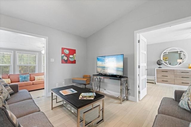 living room featuring ceiling fan, lofted ceiling, and light hardwood / wood-style flooring