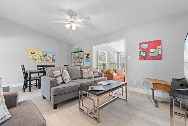 living room with light hardwood / wood-style flooring, vaulted ceiling, and ceiling fan