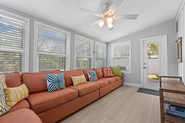 living room with light hardwood / wood-style flooring, lofted ceiling, and a wealth of natural light