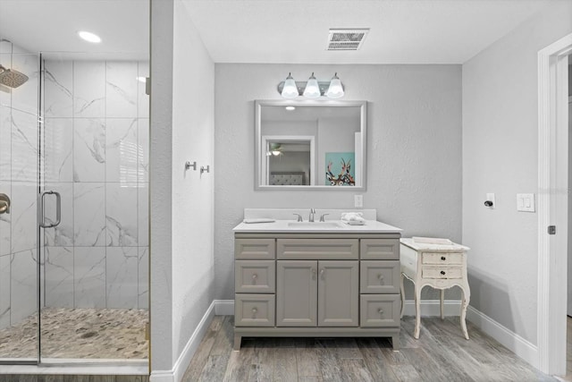 bathroom with vanity, hardwood / wood-style floors, and a shower with shower door