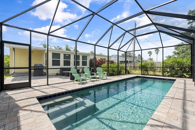 view of swimming pool with a patio area, grilling area, and glass enclosure