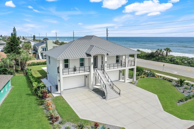 rear view of property featuring a yard, a garage, and a water view