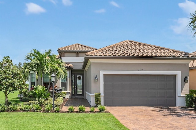 mediterranean / spanish home featuring a front yard and a garage