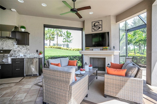 view of patio / terrace with a grill, ceiling fan, area for grilling, and an outdoor living space with a fireplace