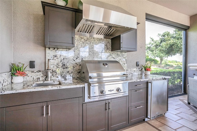 kitchen with decorative backsplash, wall chimney exhaust hood, stainless steel refrigerator, and sink