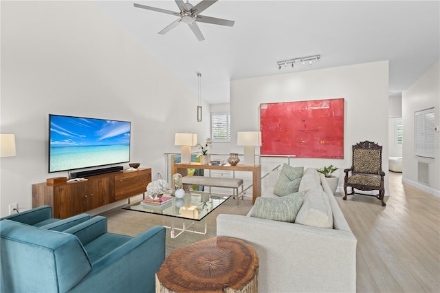 living room with light hardwood / wood-style flooring, track lighting, and ceiling fan