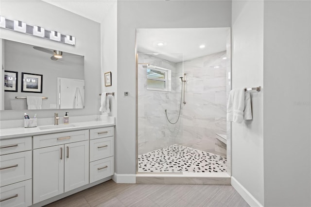 bathroom featuring vanity, tile patterned floors, a tile shower, and ceiling fan