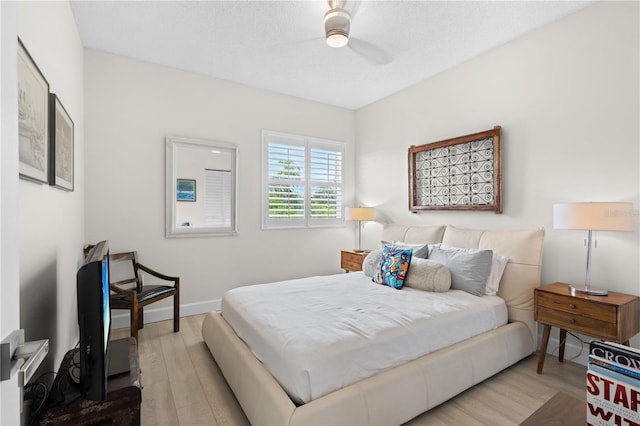 bedroom featuring ceiling fan, a textured ceiling, and light wood-type flooring