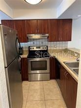 kitchen featuring appliances with stainless steel finishes, light tile patterned floors, and sink