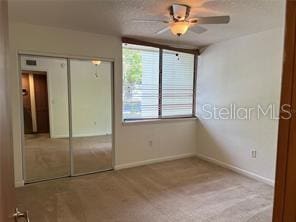 unfurnished bedroom with a closet, ceiling fan, and light colored carpet