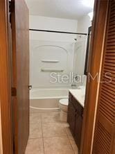 full bathroom with vanity, toilet, tile patterned floors, and shower / washtub combination