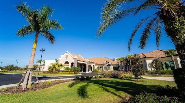 mediterranean / spanish-style home featuring a front yard