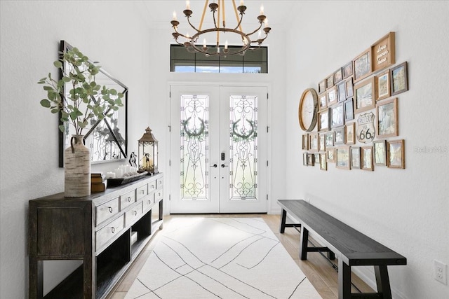 foyer entrance with an inviting chandelier and french doors