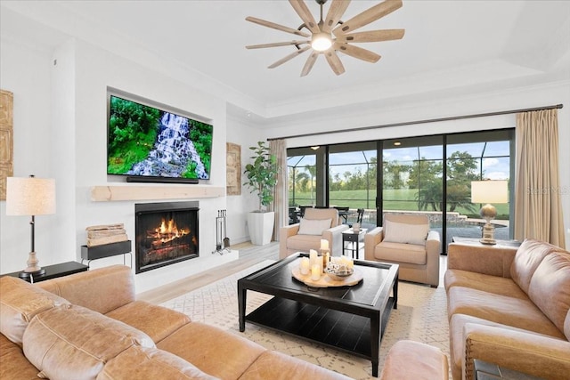 living room featuring a tray ceiling, a wealth of natural light, and ceiling fan