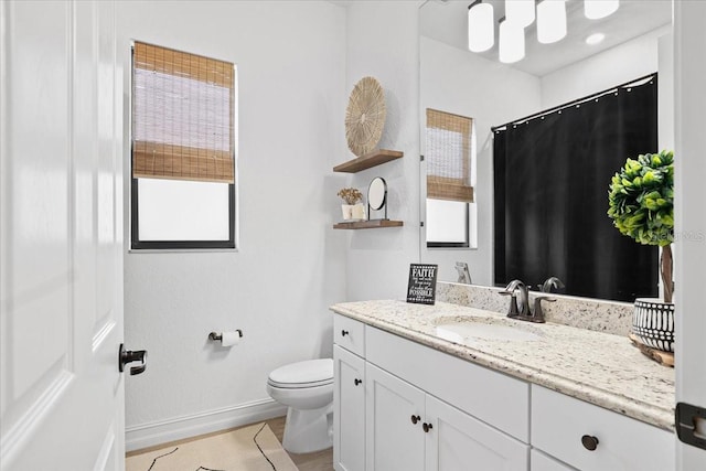 bathroom with vanity, toilet, and a wealth of natural light