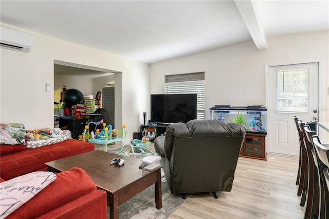 living room with a textured ceiling, light hardwood / wood-style flooring, beamed ceiling, and a wall mounted air conditioner