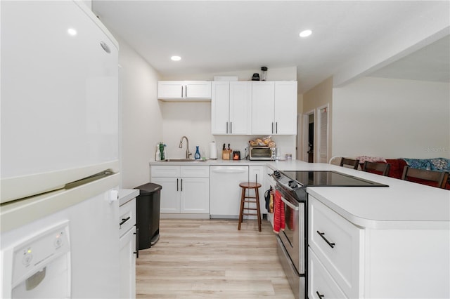 kitchen with light hardwood / wood-style flooring, white cabinets, white appliances, and sink