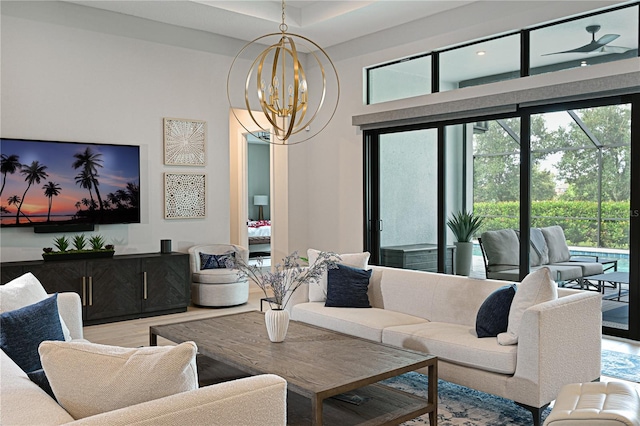 living room with hardwood / wood-style floors and ceiling fan with notable chandelier