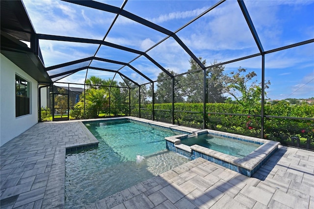 view of swimming pool featuring an in ground hot tub, a patio, and glass enclosure