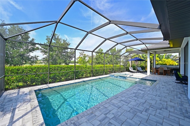 view of swimming pool with glass enclosure, exterior bar, ceiling fan, an in ground hot tub, and a patio