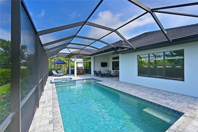 view of pool with a patio area, a lanai, and an in ground hot tub