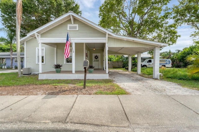 view of front facade featuring central AC unit, a carport, and covered porch