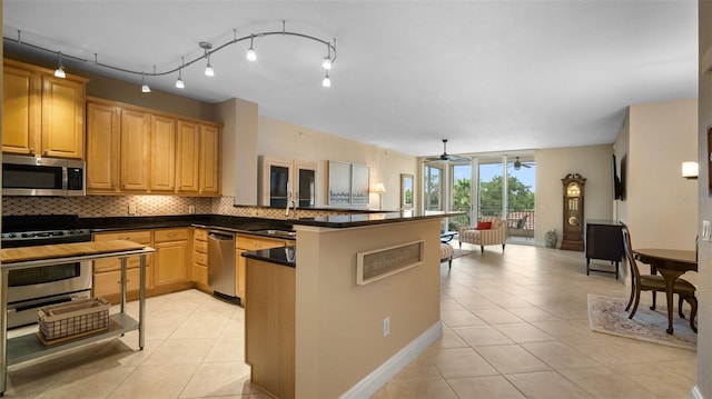 kitchen with sink, stainless steel appliances, backsplash, kitchen peninsula, and light tile patterned floors