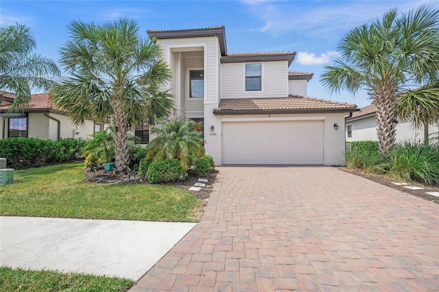 mediterranean / spanish-style house with a garage and a front lawn