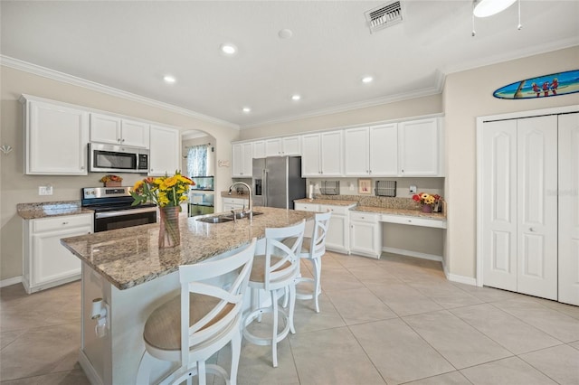 kitchen featuring a center island with sink, stainless steel appliances, sink, and white cabinetry