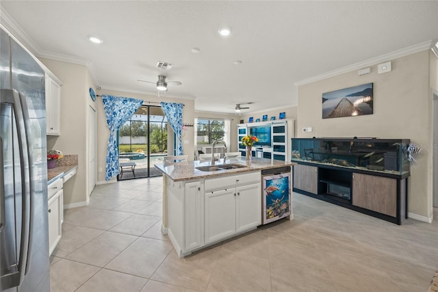 kitchen with stainless steel fridge, sink, ceiling fan, and white cabinets