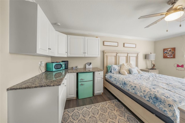 bedroom featuring ceiling fan, ornamental molding, and dark hardwood / wood-style flooring