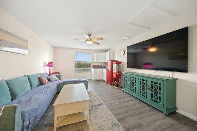 living room with ceiling fan and dark wood-type flooring