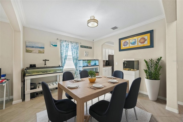 dining room with crown molding and light tile patterned floors