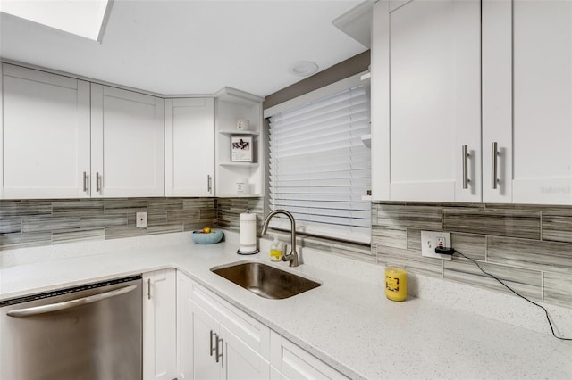 kitchen featuring white cabinets, stainless steel dishwasher, and sink