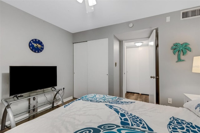 bedroom with hardwood / wood-style floors, ceiling fan, and a closet