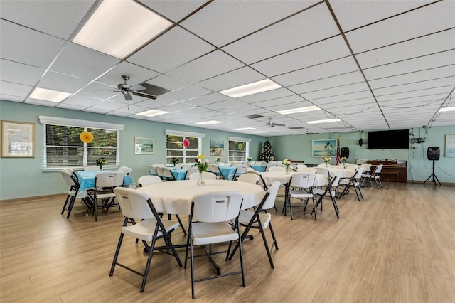 dining space with a paneled ceiling, ceiling fan, and light hardwood / wood-style floors