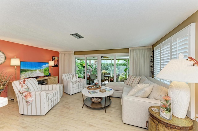 136 Crescent Dr, Anna Maria, FL 34216 - living area with visible vents, a textured ceiling, and wood finished floors