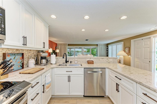 136 Crescent Dr, Anna Maria, FL 34216 - kitchen with recessed lighting, white cabinetry, tasteful backsplash, a sink, and stainless steel appliances